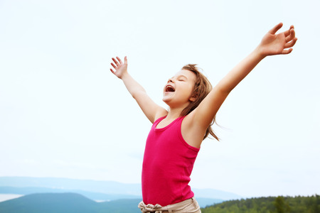 funny little  happy girl on the mountain top. children outdoors. inspirationの写真素材
