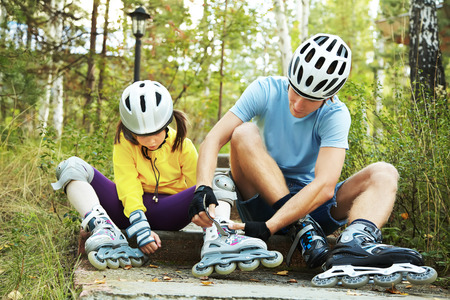 portrait of a sports dad and daughter in a helmet. Dad with his little daughter on the skatesの写真素材