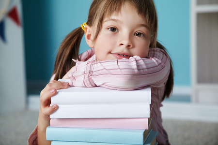girl with a stack of books. School and educationの写真素材