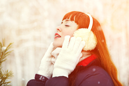 portrait of redhead woman on the winter walk in the park. people outdoorsの写真素材