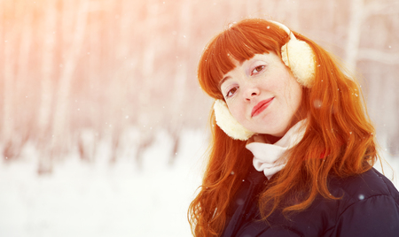 portrait of redhead woman on the winter walk in the park. people outdoorsの写真素材