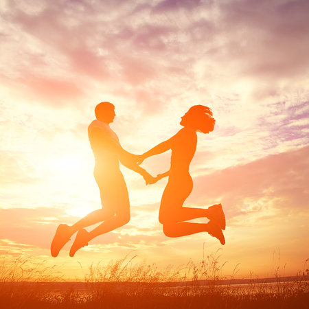 Silhouettes of a young couple lovers at sunset in rays of setting sun. people outdoors