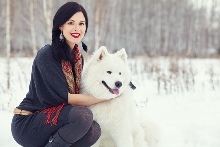 Dog breed Samoyed husky with woman outdoors. dog for a walk with his ownerの写真素材
