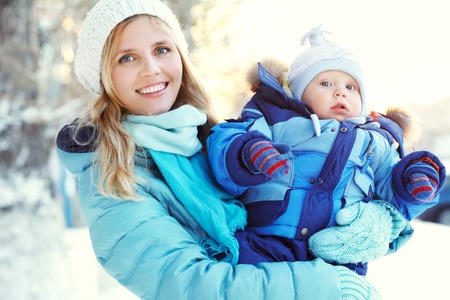 happy mother and baby in winter parkの写真素材