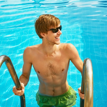 man relaxing by swimming poolの写真素材