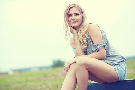 attractive woman with a suitcase outdoor. blonde stylish girlの写真素材