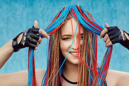 woman with bright makeup and colored cornrowsの写真素材