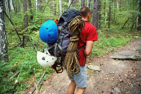 hiker with backpack goes on a forest roadの写真素材