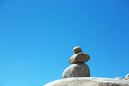 stacked stones in the mountains on sky backgroundの写真素材