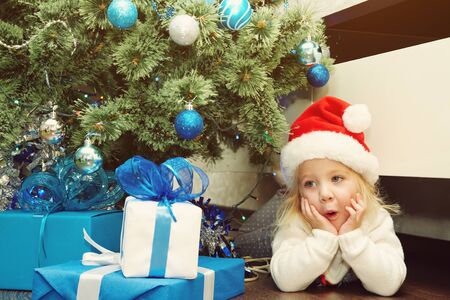 little girl in santa hat holding a giftの写真素材