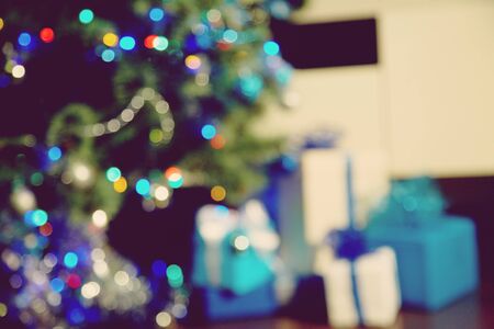 gift boxes under decorated christmas tree. blurred xmas and new year background.の写真素材