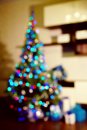 gift boxes under decorated christmas tree. blurred xmas and new year backgroundの写真素材