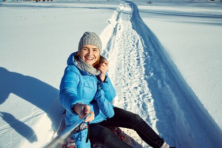 cheerful woman in the winter taking selfie photo.