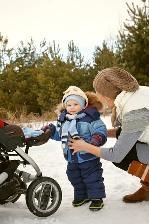 happy mother and baby in winter. family outdoors. cheerful mommy with her child.の写真素材