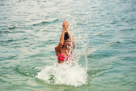 young playful woman relaxing in sea water.の写真素材