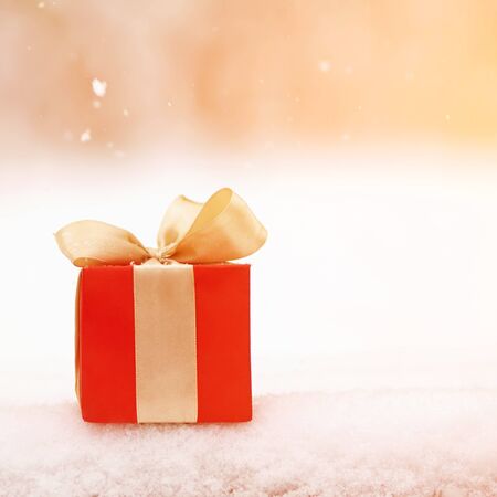 red winter Christmas gift box in snow background outdoors.の写真素材
