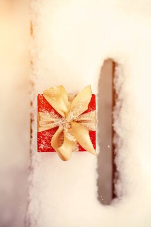 red winter Christmas gift box in snow background outdoors.の写真素材