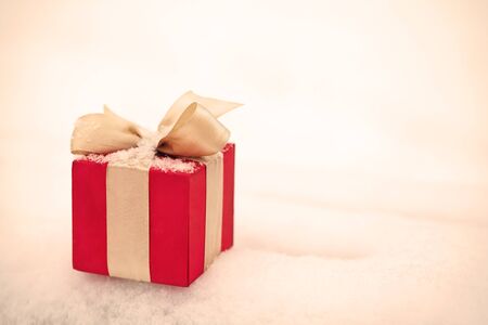 red winter Christmas gift box in snow background outdoors.の写真素材