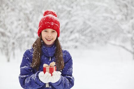 teenage girl with a gift in her hands. adolescent winter outdoorsの写真素材