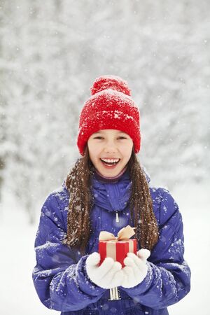 teenage girl with a gift in her hands. adolescent winter outdoorsの写真素材
