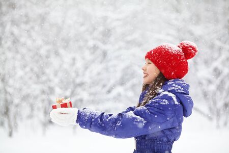 teenage girl with a gift in her hands. adolescent winter outdoorsの写真素材