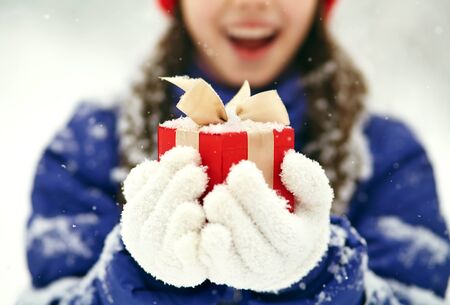 teenage girl with a gift in her hands. adolescent winter outdoorsの写真素材