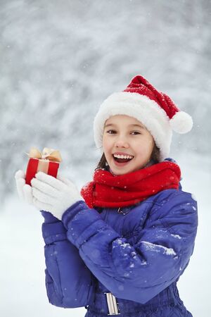 teenage girl with a gift in her hands. adolescent winter outdoorsの写真素材