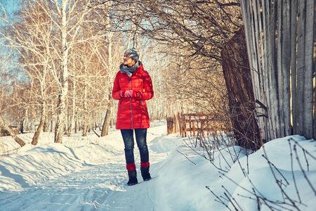 walking woman in a hat and scarf in the winterの写真素材