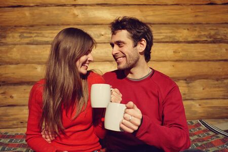 man and woman drinking tea at home. couple in love with mugs in handsの写真素材