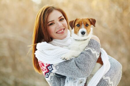 Jack Russell Terrier dog with owner woman in the winter outdoors.の写真素材