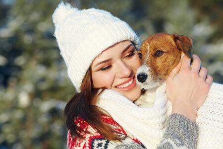 Jack Russell Terrier dog with owner woman in the winter outdoors.の写真素材