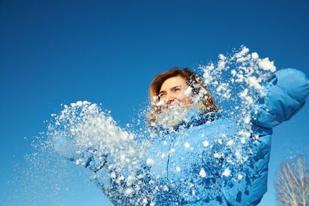 happy woman on a walk in the winter. girl outdoors enjoying snow.の写真素材