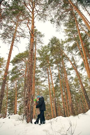 Young happy couple in love in the winter forest. Man and woman outdoorsの写真素材