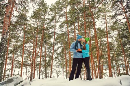 Young happy couple in love in the winter forest. Man and woman outdoorsの写真素材