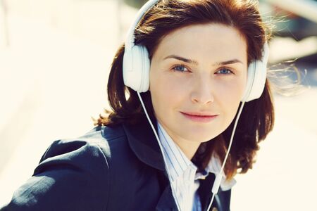 outdoor portrait of a stylish woman with headphones in a street.の写真素材