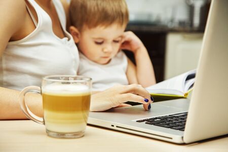 Mother with child works at the computerの写真素材
