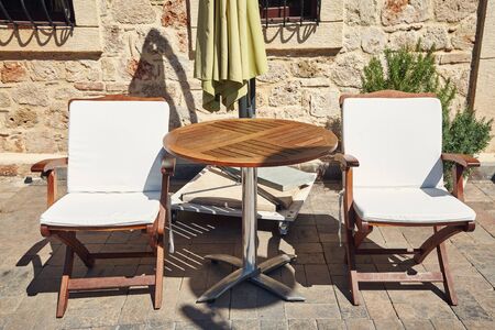 empty street cafe with wooden chairs and tablesの写真素材