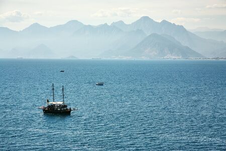 tourist sailing ship in a bay on background of mountainsの写真素材
