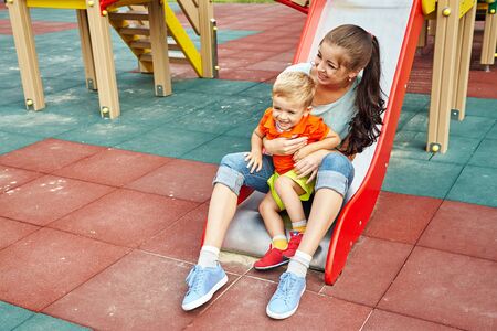 mother playing with her baby on playgroundの写真素材
