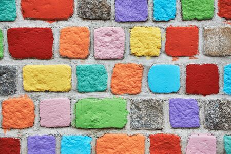 Stone multicolored wall. Brick painted background in colors of the rainbowの写真素材