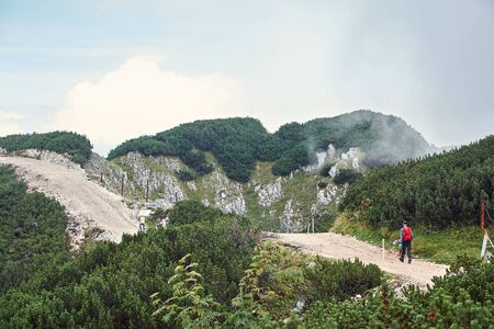 climber on trail in the mountains. a man with a backpack in a hike.の写真素材