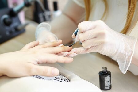 beautician making hardware manicure. woman hands receiving nail procedure in beauty salon.の写真素材