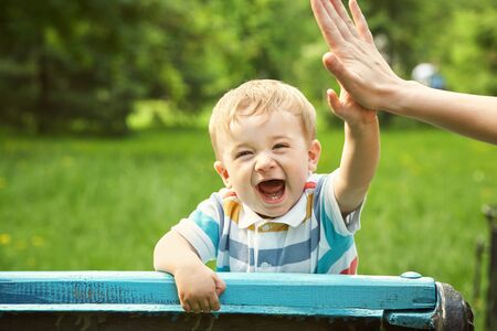 outdoor portrait of a boy on green background. happy child on walking in summer park.の写真素材