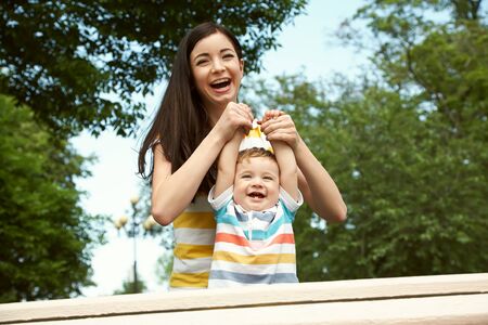 mother with her child outdoor. Mom and son walking in summer park.の写真素材