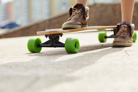 skater with a longboard closeup. trendy casual hipster person a skateboard.の写真素材