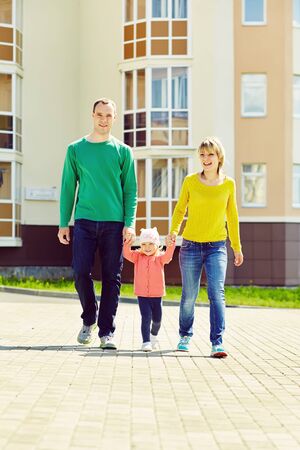 happy playing family outdoors. young parents with a baby walking in the summer. Mom, dad and child.の写真素材