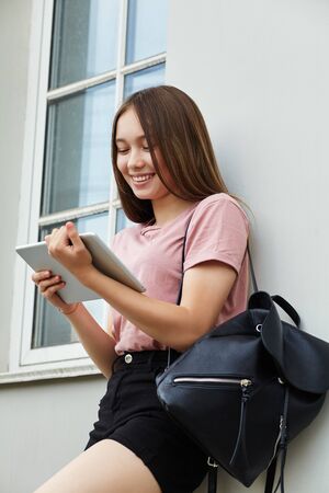 Girl using a tablet computer. Student near university.の写真素材