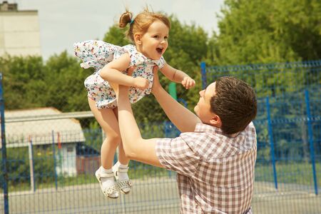 outdoor playing father and daughter. dad throws up the child.の写真素材