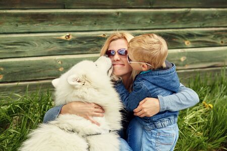 outdoor portrait mother, son and dog. child and mom walking samoyed laika.の写真素材