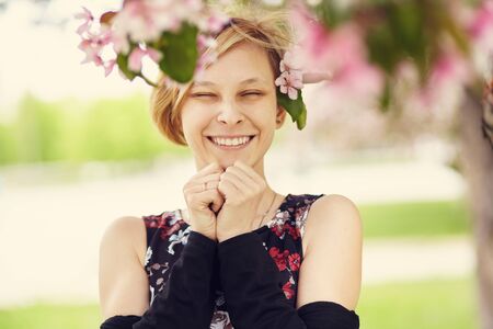Beautiful smiling young woman with spring flowers in her hair.の写真素材